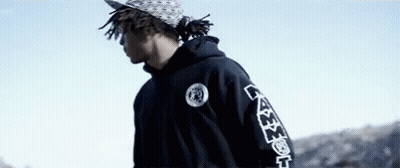 Young Man In Black Hoodie And Hat Against Blue Sky GIF