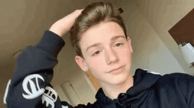 Young Man In Black Hoodie Holding Hair GIF