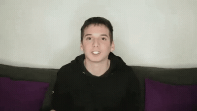Young Man In Black Hoodie With Funny Face On Purple Couch GIF