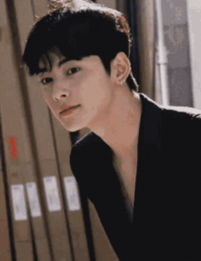 Young Man In Black Jacket And Earrings Looking At Camera GIF