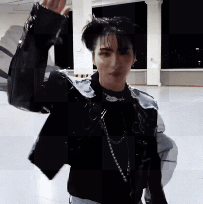 Young Man In Black Jacket And Necklace On Concrete Floor GIF