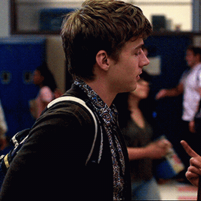 Young Man In Black Jacket And Paisley Shirt In Hallway GIF