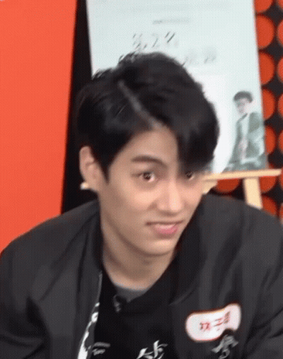Young Man In Black Jacket Making Funny Face At Easel GIF