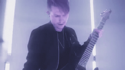 Young Man In Black Jacket Playing Guitar In Dark Room GIF