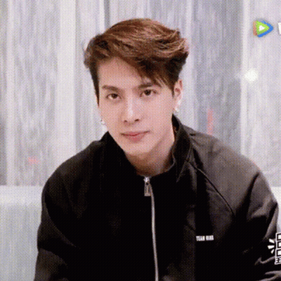 Young Man In Black Jacket Sitting On Couch GIF