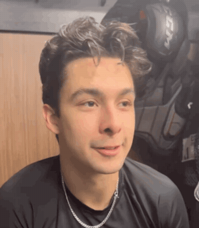 Young Man In Black Shirt And Silver Chain In Locker Room GIF