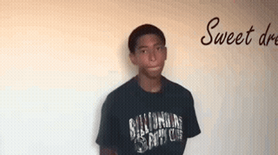 Young Man in Black Shirt Saying Billionaire in Front of Sweet Dream Wall