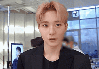 Young Man In Black Suit Standing In Front Of Window GIF