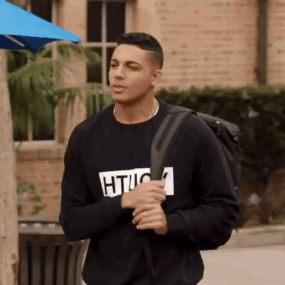 Young Man In Black Sweatshirt And Backpack GIF