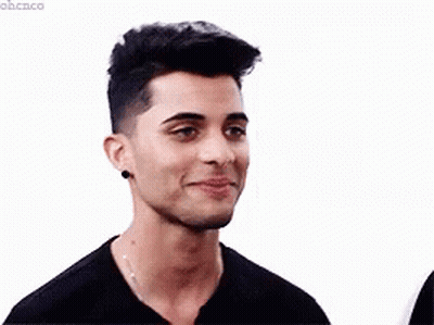 Young Man In Black Turtleneck And Necklace Smiling GIF