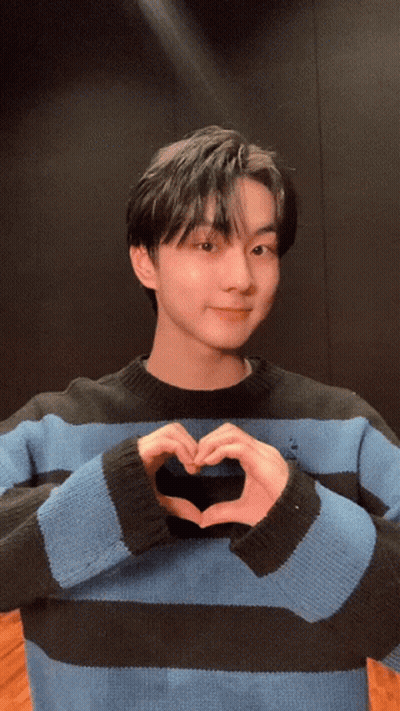 Young Man In Blue And Black Striped Sweater Making Heart Shape GIF