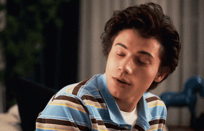 Young Man In Blue And Brown Striped Shirt Looking At Camera GIF