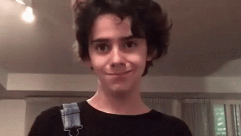 Young Man In Blue Geek Shirt In Front Of Stop Sign GIF