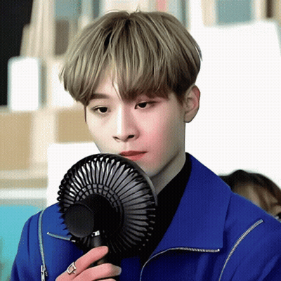 Young Man In Blue Jacket Holding Fan GIF