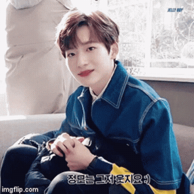 Young Man In Blue Jacket Sitting By Window GIF