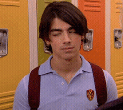 Young Man In Blue Polo And Red Backpack By Lockers GIF