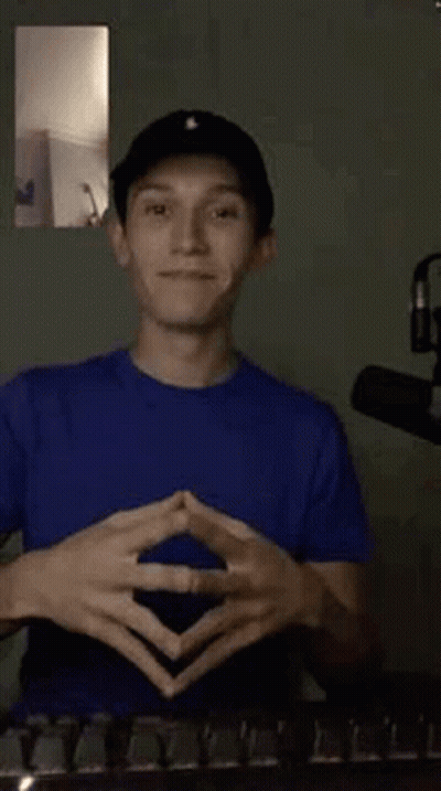 Young Man In Blue Shirt And Black Hat Making Funny Face GIF