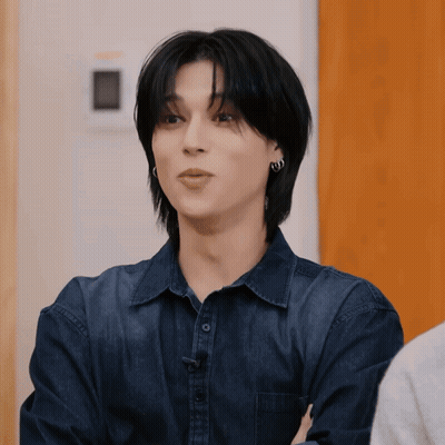 Young Man In Blue Shirt And Earrings Staring GIF