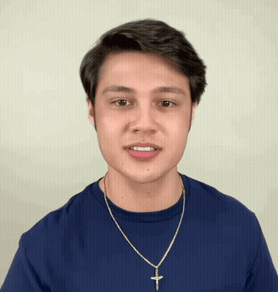 Young Man In Blue Shirt And Necklace Making Face GIF