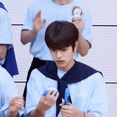 Young Man In Blue Shirt And Tie Holding Blue Object GIF