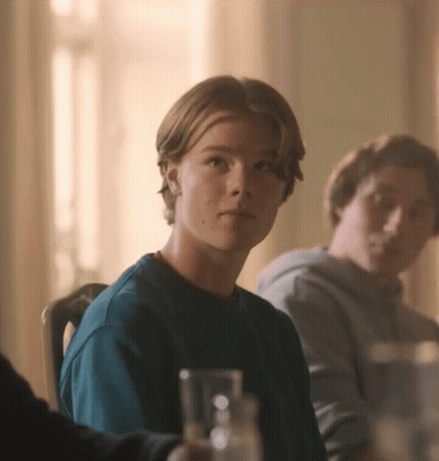Young Man In Blue Shirt At Table GIF