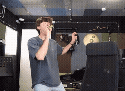 Young Man In Blue Shirt Covering Face Holding Microphone GIF