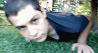 Young Man In Blue Shirt Doing Push Ups In Grass GIF
