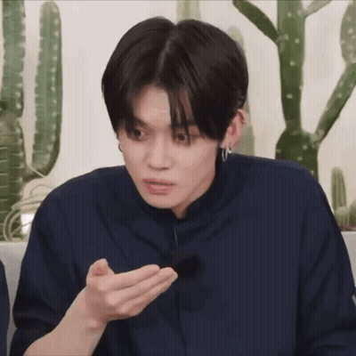 Young Man In Blue Shirt Holding Something Near Cactus GIF