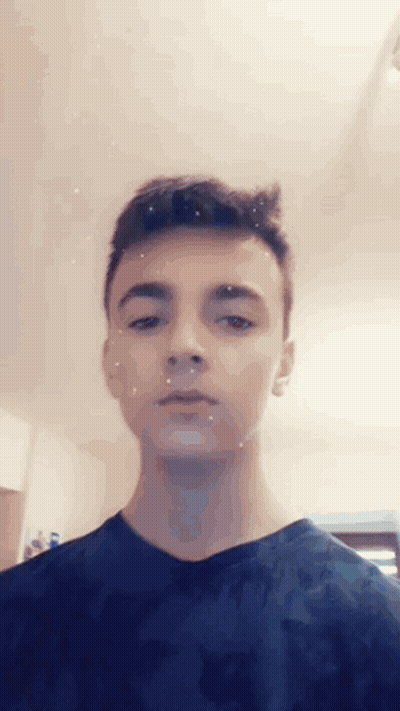 Young Man In Blue Shirt Looking At Camera GIF