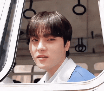 Young Man In Blue Shirt Looking Out Window GIF