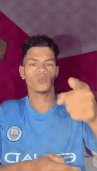 Young Man In Blue Shirt Pointing And Blowing Kiss GIF