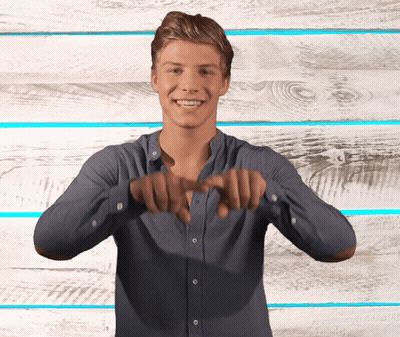Young Man In Blue Shirt Smiling Making Heart Shape GIF