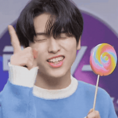 Young Man In Blue Sweater Holding Lollipop Thumbs Up GIF