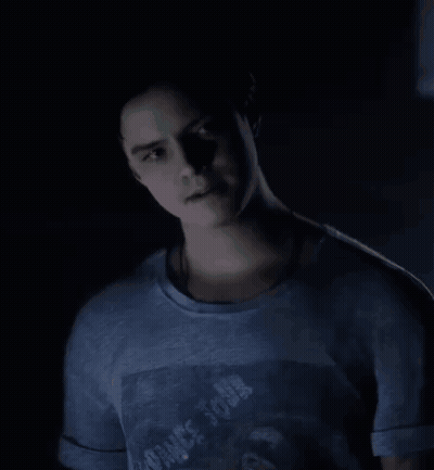 Young Man In Blue T-Shirt With Man Picture Standing In Dark Room GIF