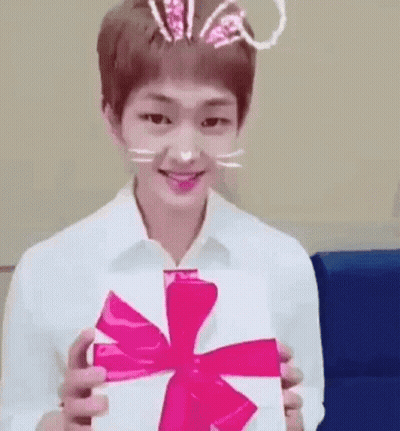 Young Man In Bunny Ears Holding White Box With Pink Bow GIF