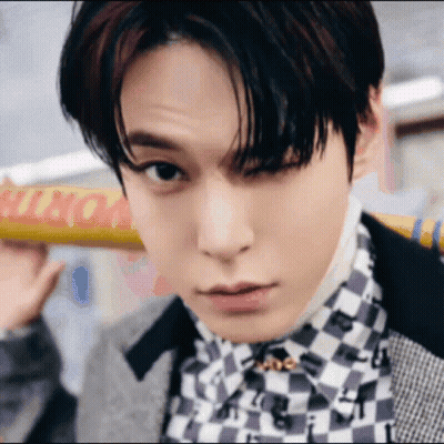 Young Man In Checkered Shirt Holding Yellow Sign GIF