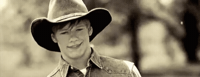 Young Man In Cowboy Hat And Denim Vest Smiling GIF