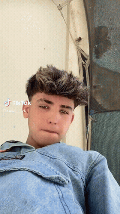 Young Man In Denim Jacket Looking At Camera GIF