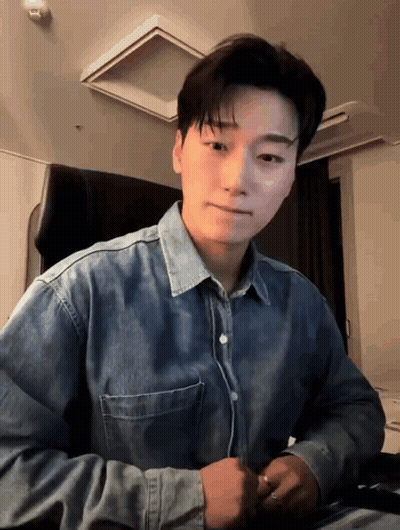 Young Man In Denim Shirt Sitting GIF