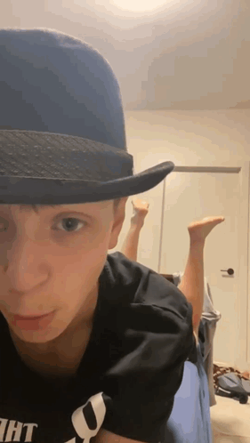 Young Man In Fedora Lying On Bed GIF