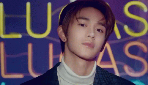 Young Man In Front Of Lucas Neon Sign GIF