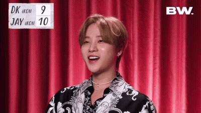 Young Man In Front Of Red Curtain With BW Sign GIF
