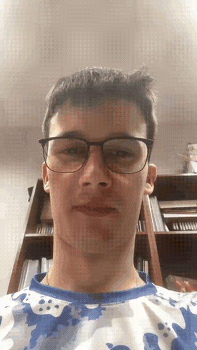 Young Man In Glasses And Camo Shirt Looking At Camera GIF