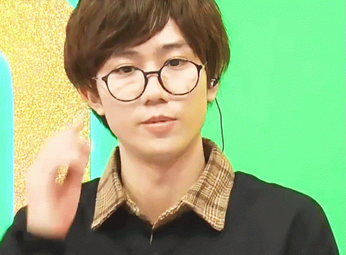 Young Man in Glasses and Plaid Shirt Making Gesture