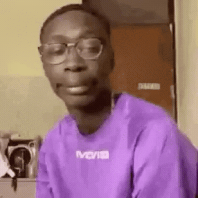 Young Man In Glasses And Purple Shirt Making Face GIF