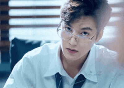 Young Man In Glasses White Shirt And Tie Sitting At Table GIF