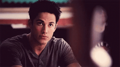 Young Man In Gray Shirt Sitting At Table GIF