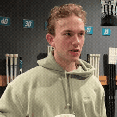 Young Man In Green Hoodie In Front Of Numbered Wall GIF