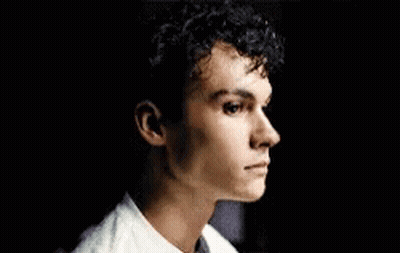 Young Man In Green Shirt Sitting On Couch Eyes Closed GIF