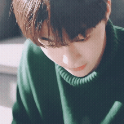 Young Man In Green Sweater Looking Down GIF